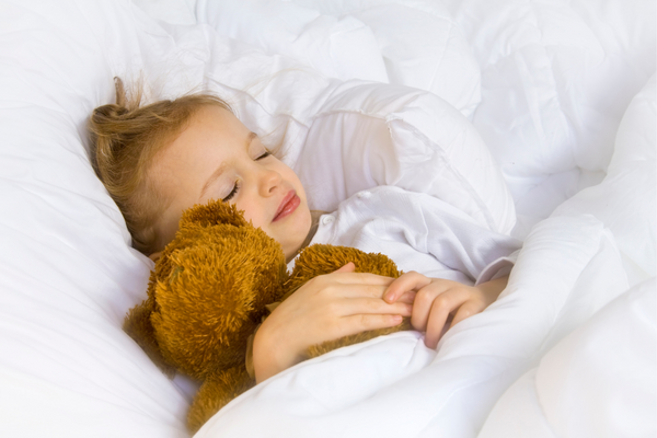 Girl sleeping with her teddy
