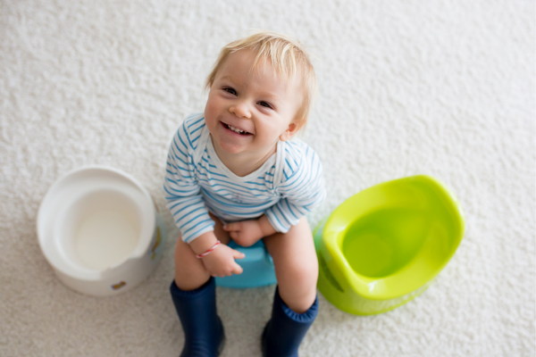 Toddler sitting on a potty smiling