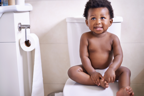 Boy sitting on a toilet smiling