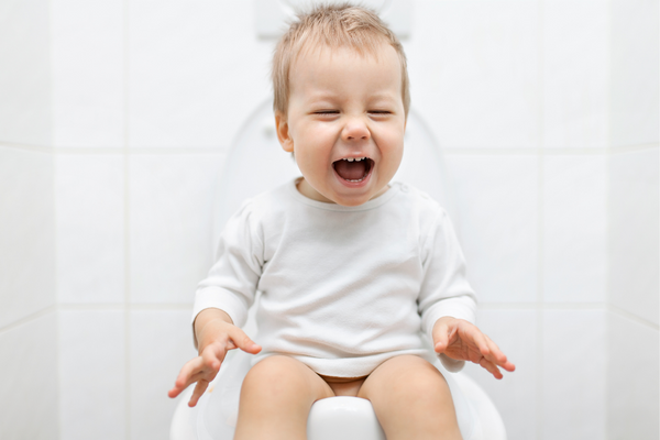 Toddler sitting on a toilet having a tantrum