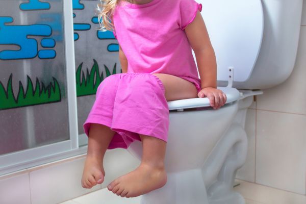 Girl sitting on the toilet potty training